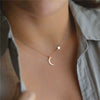 Celestial Star Moon Clavicle Necklace – gold chain with star and moon motifs on a model’s collarbone