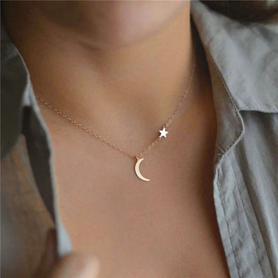 Celestial Star Moon Clavicle Necklace – gold chain with star and moon motifs on a model’s collarbone