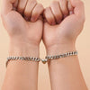 Couple wearing matching bracelets, showcasing unisex design and magnetic hearts.