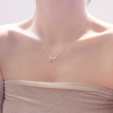 Delicate Silver Bowknot Necklace – handcrafted pendant on an adjustable chain, styled on a model