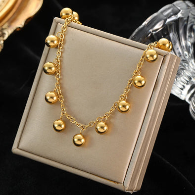 Polished golden beads and stainless steel chain texture in close-up