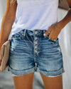 Front view of women's ripped denim shorts with curled hem